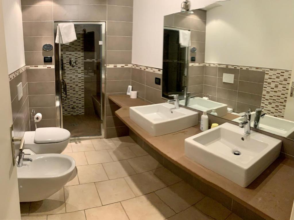 uma casa de banho com 2 lavatórios e um WC em Appartamento Piè em Canazei