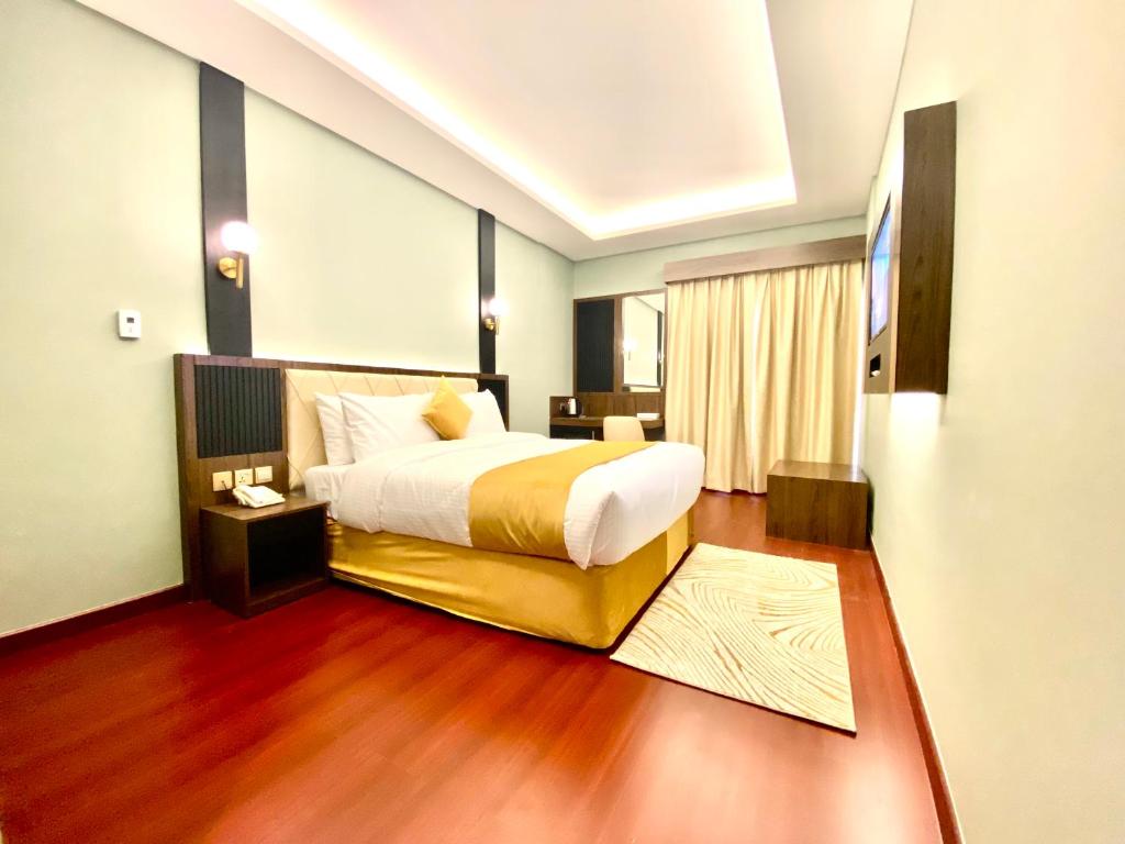 Habitación de hotel con cama y suelo de madera. en Concorde Inn Hotel, en Dubái