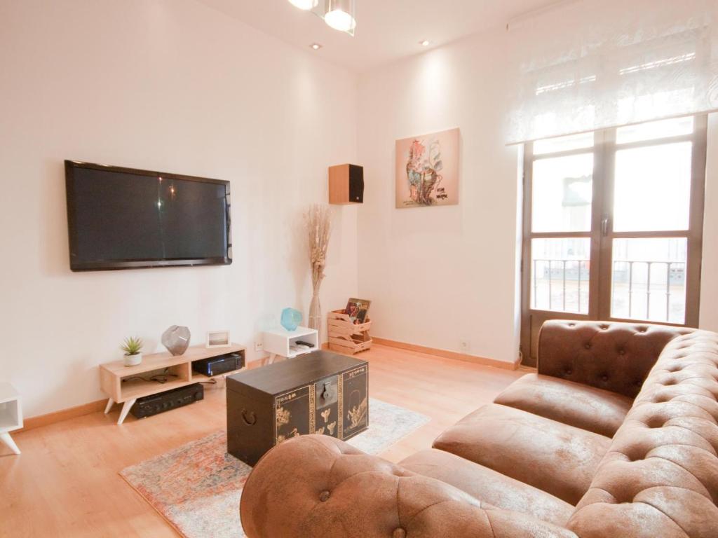 een woonkamer met een bank en een flatscreen-tv bij Apartamento Turistico Cava Alta in Madrid