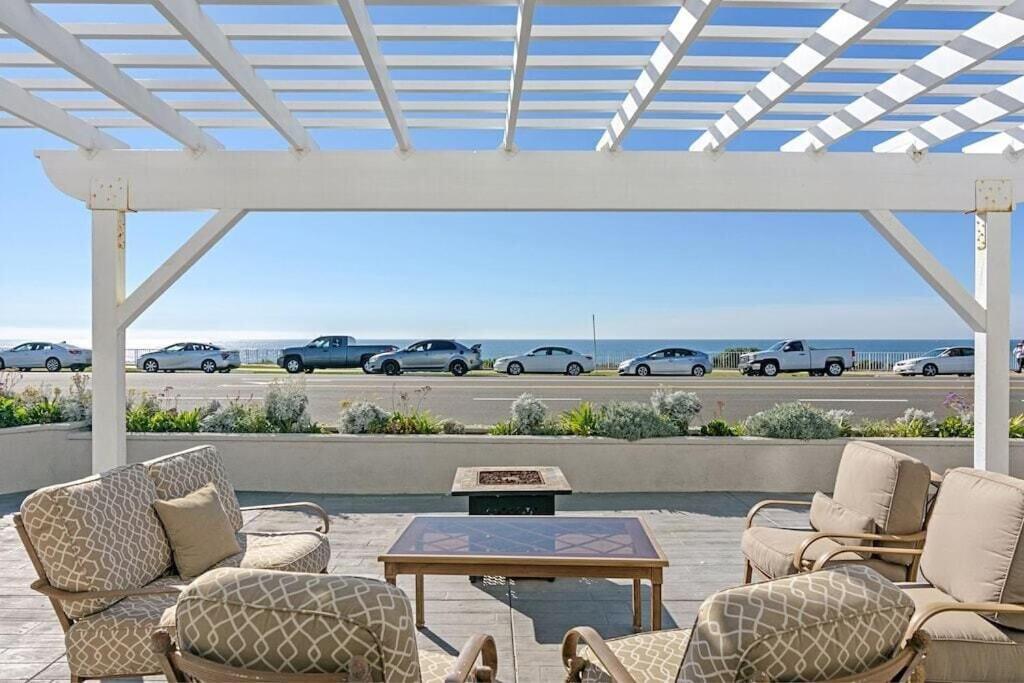 a patio with chairs and a table and cars in a parking lot at Ocean Views, Across The Street From Beach, Private Patio in Carlsbad