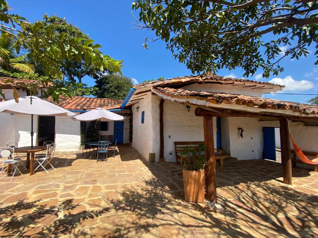 a patio with tables and umbrellas in front of a building at El Principito Hospedaje in Barichara