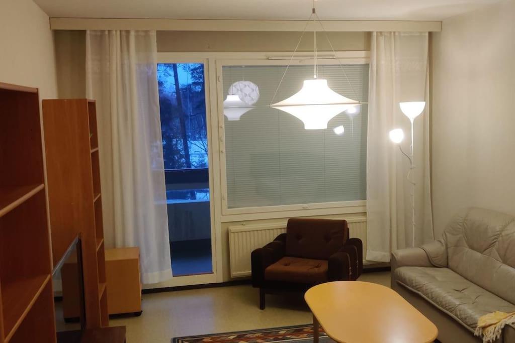 een woonkamer met een bank, een stoel en een raam bij Mediocre budget 2 rm apartment in Merirauma in Rauma