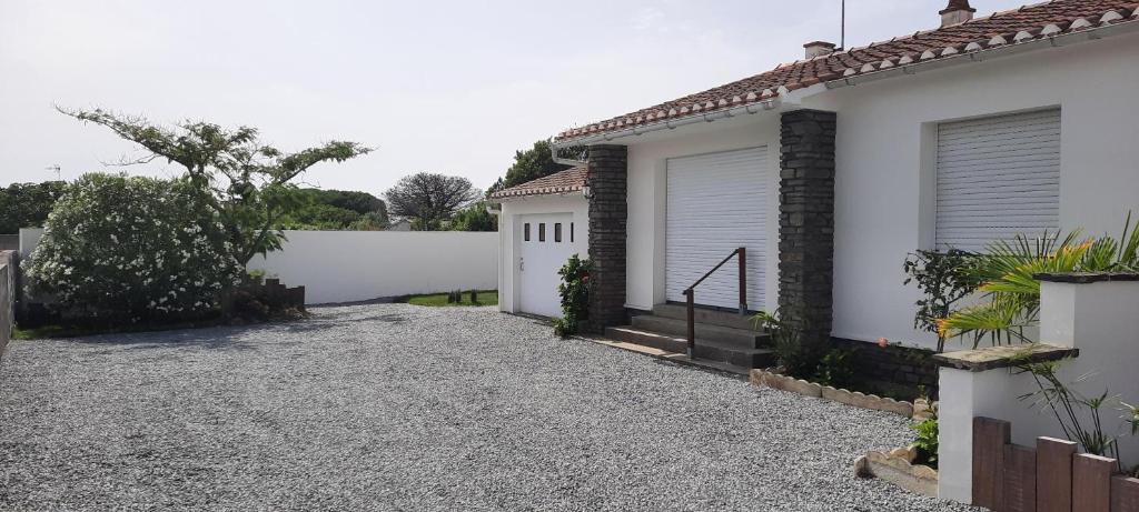 eine Auffahrt eines Hauses mit einem weißen Zaun in der Unterkunft Ma maison au bord de la mer in Saint-Hilaire-de-Riez