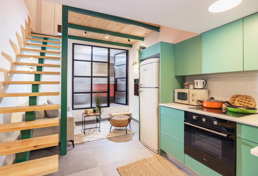 a kitchen with green cabinets and a staircase at Cozy Studio in Old Town in Tel Aviv