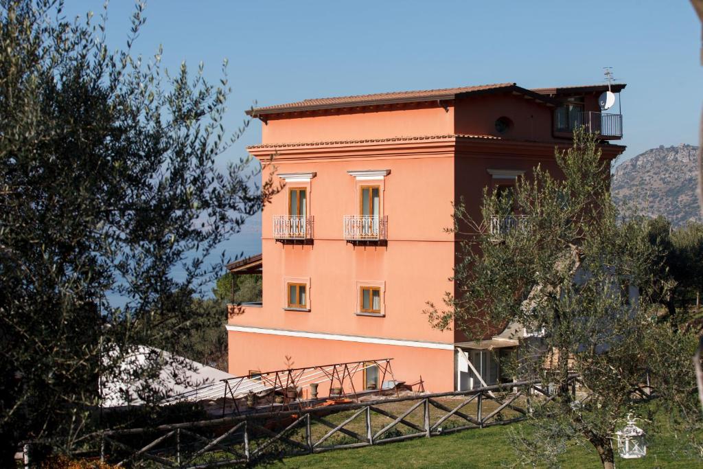 a pink building with a balcony on a hill at Antico Casale Russo in Piano di Sorrento