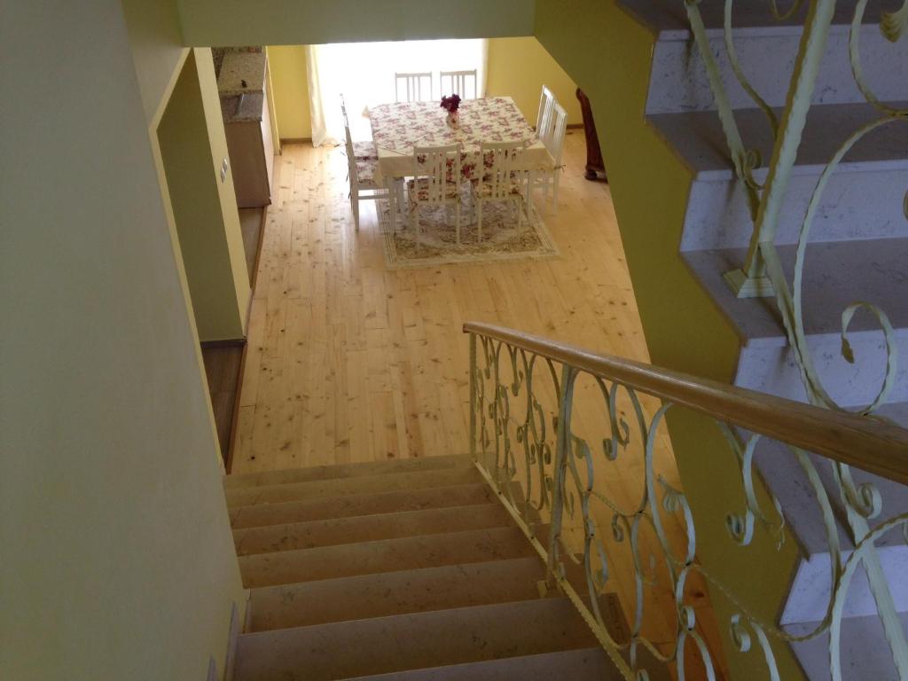 una escalera que conduce a un comedor con mesa en Zlatina Guest House, en Lŭga