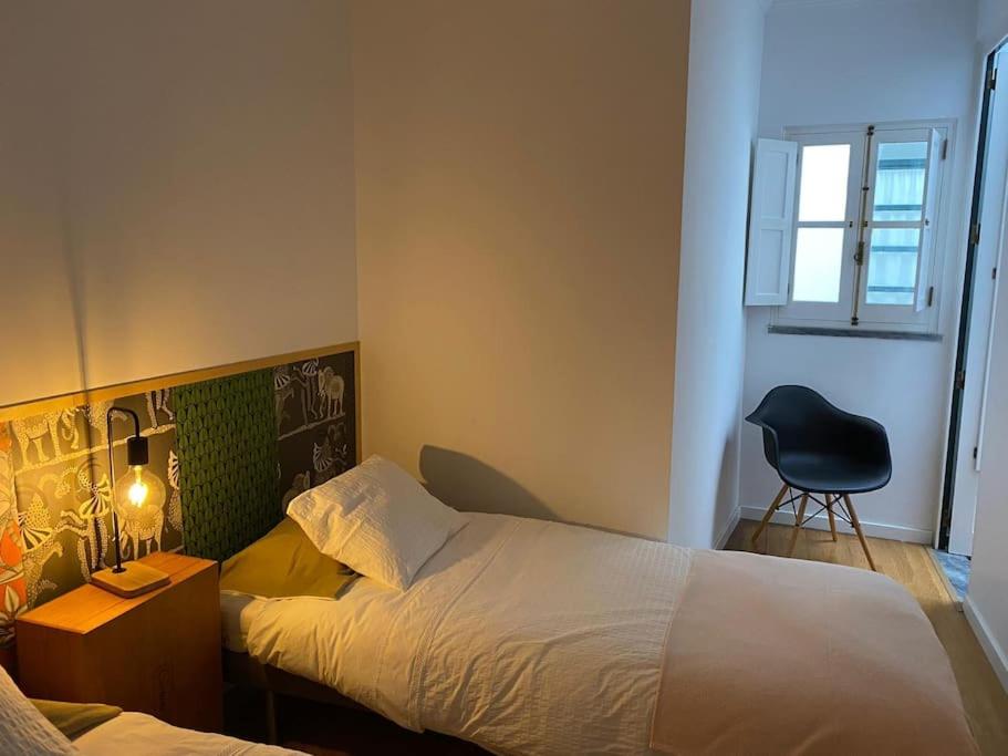 een slaapkamer met een bed, een bureau en een stoel bij GALLE - Apartamento dos Infantes in Beja