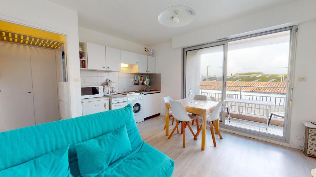 - un salon avec un canapé et une table dans l'établissement Appartement Les Embruns, à Saint-Gilles-Croix-de-Vie