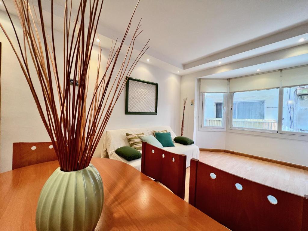 a living room with a vase on a table at Prop de mar a 60m de la playa in Calafell