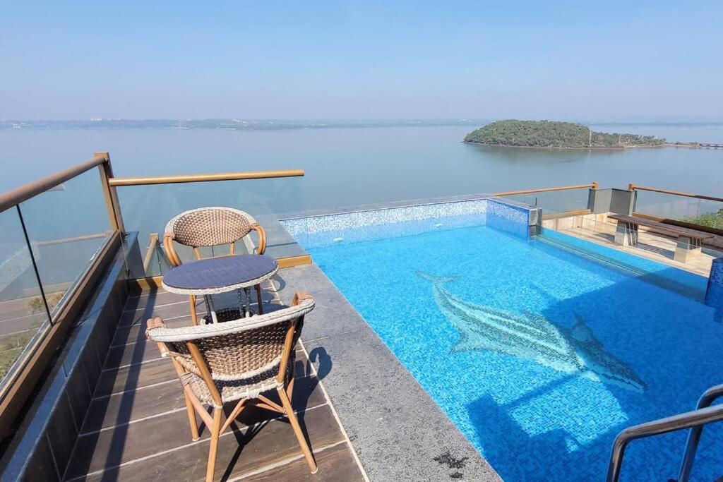 a swimming pool with a table and chairs on a balcony at RK island view villa in Dabolim