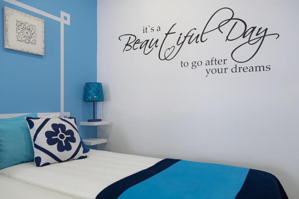 a bedroom with a bed with a happy first day wall decal at Chez New Best Charm e Design - Your Seaside Dream! in Lagos