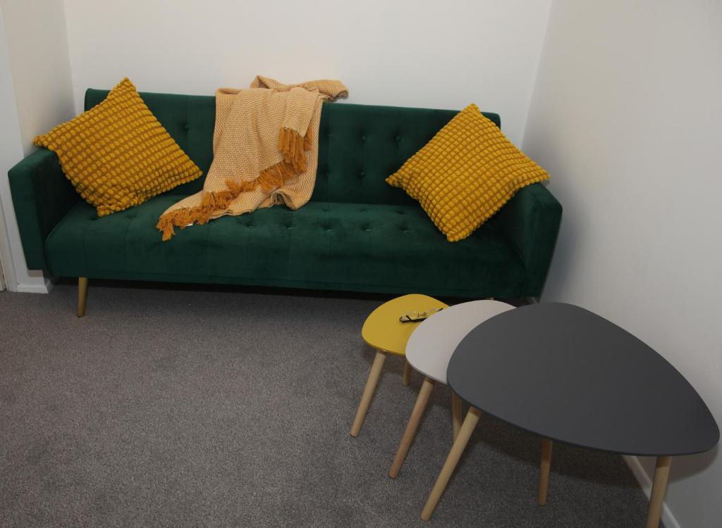 uma sala de estar com um sofá verde e uma mesa em The Annexe em Thorpe