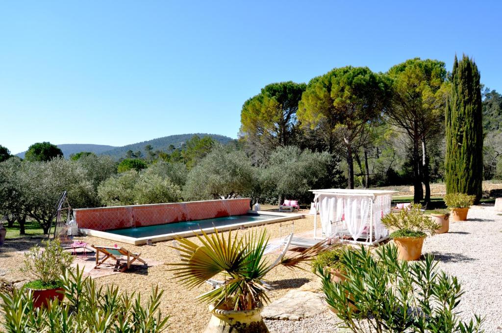 una piscina en un jardín con plantas y árboles en La Bastide de la Provence Verte, chambres d'hôtes, en La Roquebrussanne
