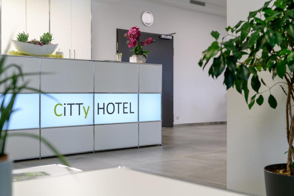 施韋因福特的住宿－CiTTy Hotel Schweinfurt，墙上挂有城市酒店标志的办公室