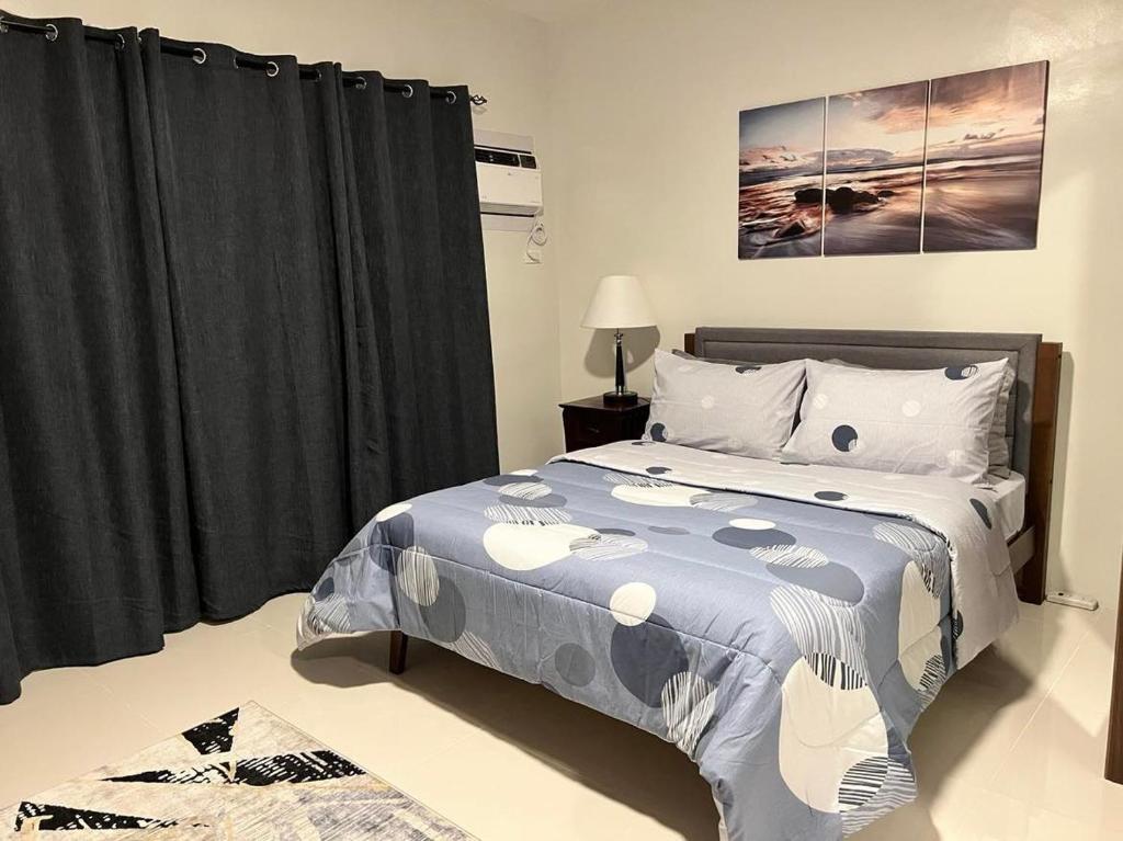 a bedroom with a bed with a blue comforter at 7F Majorca, Camella Manors Bacolod Condo in Bacolod