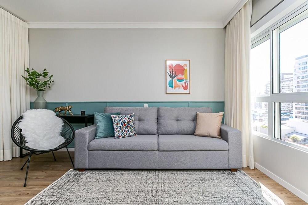 sala de estar con sofá y ventana en K-Platz 406 - Studio Elegante e Moderno na Melhor Localização do Continente en São José