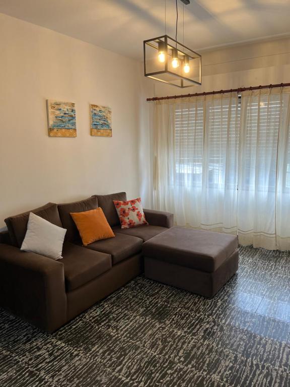 - un salon avec un canapé brun et une fenêtre dans l'établissement Magnolia Departamento Céntrico, à San Fernando del Valle de Catamarca