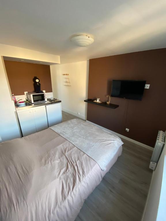 CarcagnyにあるLa Dilichambreのベッドとテレビが備わるホテルルームです。