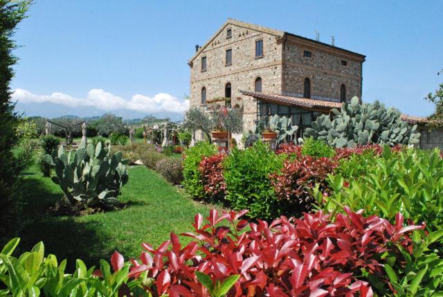 un gran edificio de piedra en un jardín con cactus en Locanda Dei Cocomeri, en Montalto Uffugo