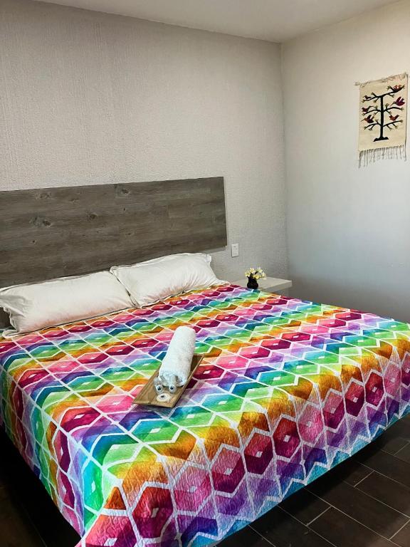 a bed with a colorful blanket on top of it at Casa Biznaga in Oaxaca City