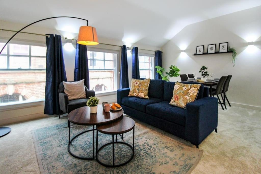 ein Wohnzimmer mit einem blauen Sofa und einem Tisch in der Unterkunft Luxurious 2 Bedroom Apartment in City Centre in Nottingham