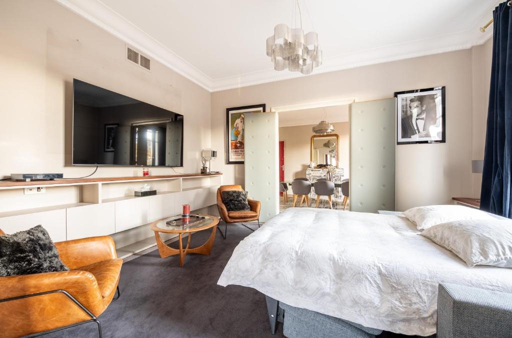a bedroom with a bed and a living room at Spacieux et élégant appartement Porte des ternes in Paris
