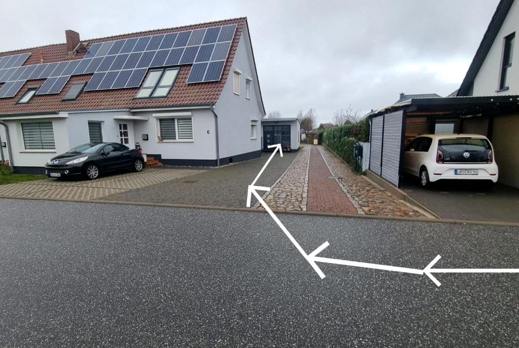 um carro estacionado num parque de estacionamento com painéis solares em Fewo Ostseenähe em Bentwisch