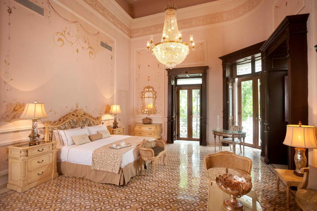 a bedroom with a bed and a chandelier at Mansi&oacute;n M&eacute;rida Boutique Hotel - Restaurant in M&eacute;rida