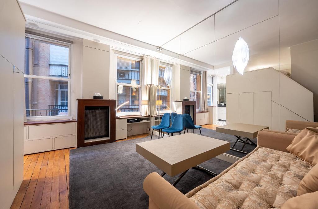 a living room with a couch and a table at Élégant studio avec mezzanine porte des Ternes in Paris