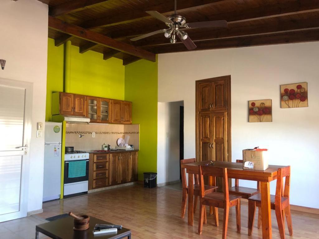cocina con mesa y algunas paredes verdes en Departamentos Mareas en San Antonio Oeste