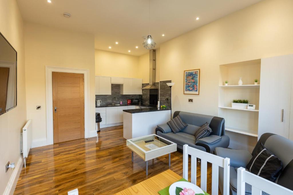 uma sala de estar com um sofá e uma mesa em New 2 bed apartment with stunning views of Arthur Seat Mountain em Edimburgo