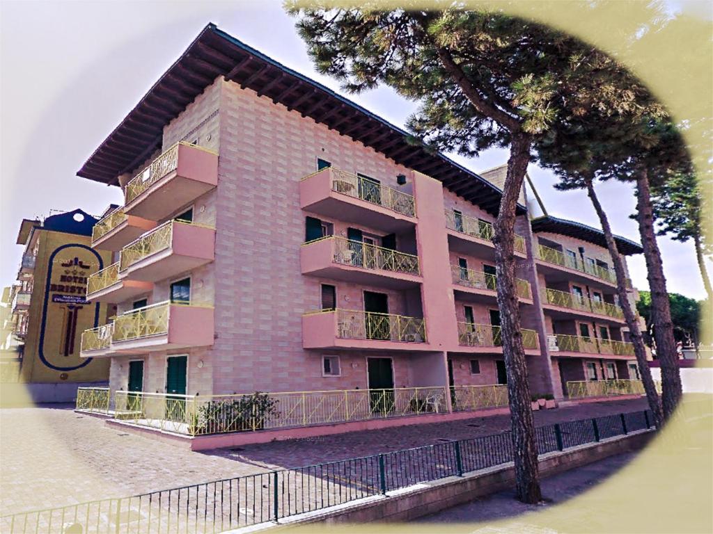 a pink building with a tree in front of it at Residence Soleil - Agenzia Cocal in Caorle