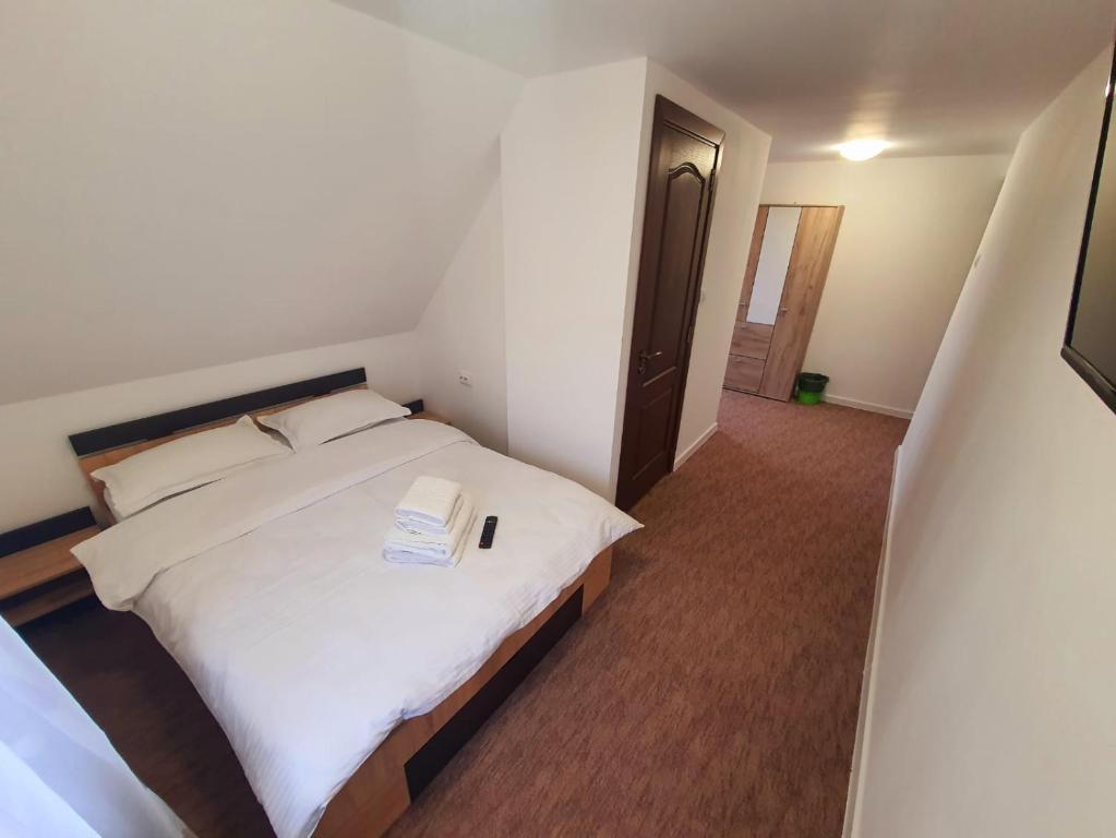 ein Schlafzimmer mit einem weißen Bett in einem Zimmer in der Unterkunft Casa Edi in Poiana Negrii