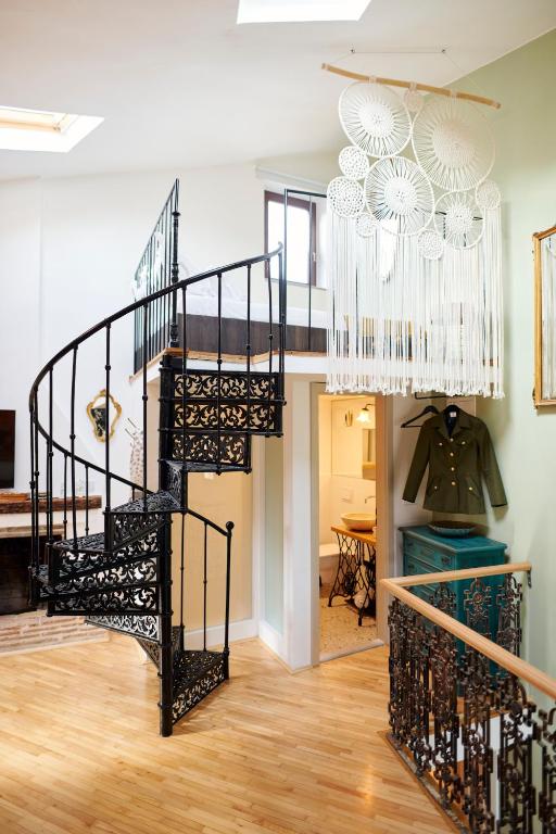 a spiral staircase in a living room with a chandelier at MM Apartments in Koper