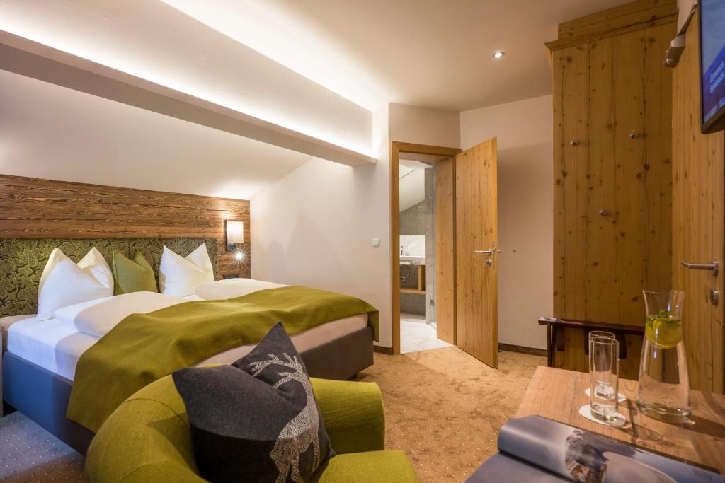 a hotel room with a bed and a couch at Landhotel Lechner Appartements in Kirchberg in Tirol