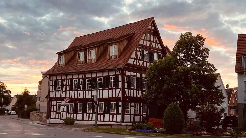 un bâtiment marron et blanc avec un toit brun dans l'établissement Rose Boardinghouse, à Großbottwar