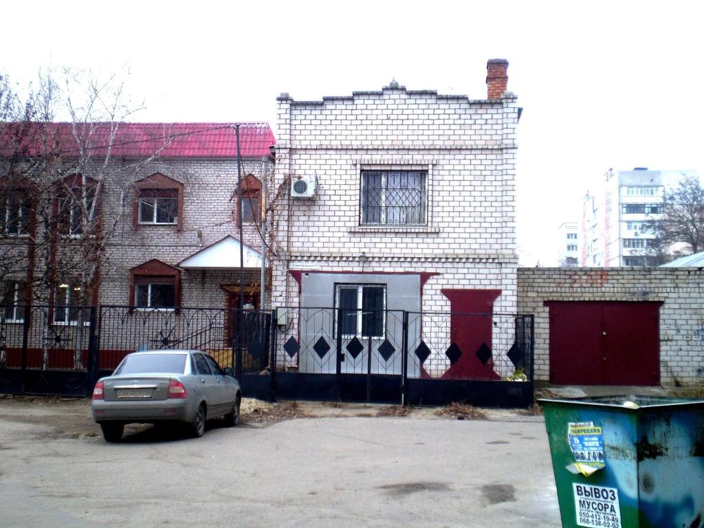 un coche aparcado frente a una casa de ladrillo en 2 КОМНАТЫ 4 дивана ЧКАЛОВА-САДОВАЯ "Сити центр" 2 этаж WI-FI 2 этажный отдельный дом, en Mykolaiv