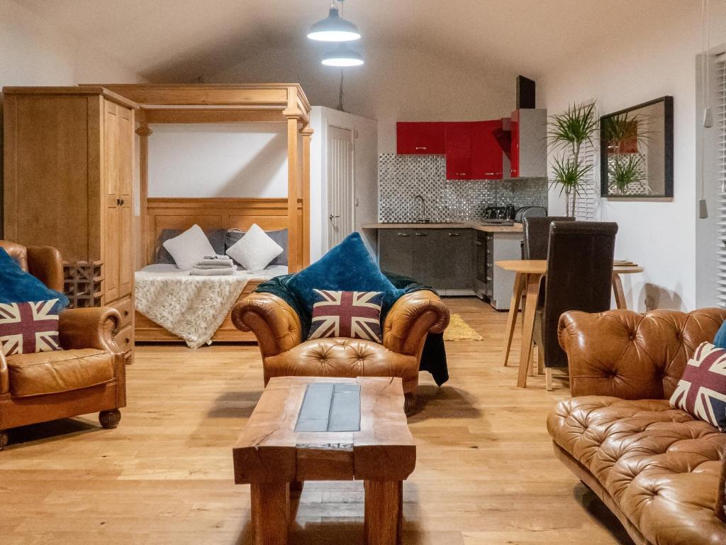 a living room with two couches and a bed at Ty Afon Arch - Uk38515 in Garnant