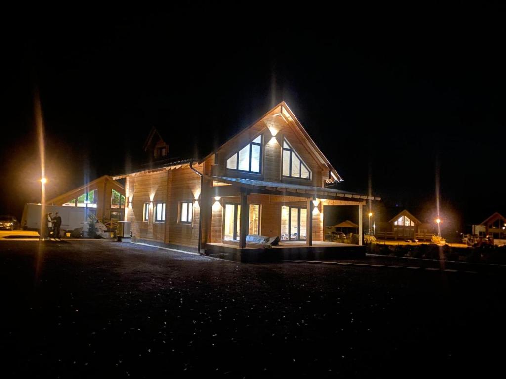 ヴェルカー・ロムニツァにあるVila Lomnica Vysoké Tatryの夜の灯り付きの大きな木造家屋