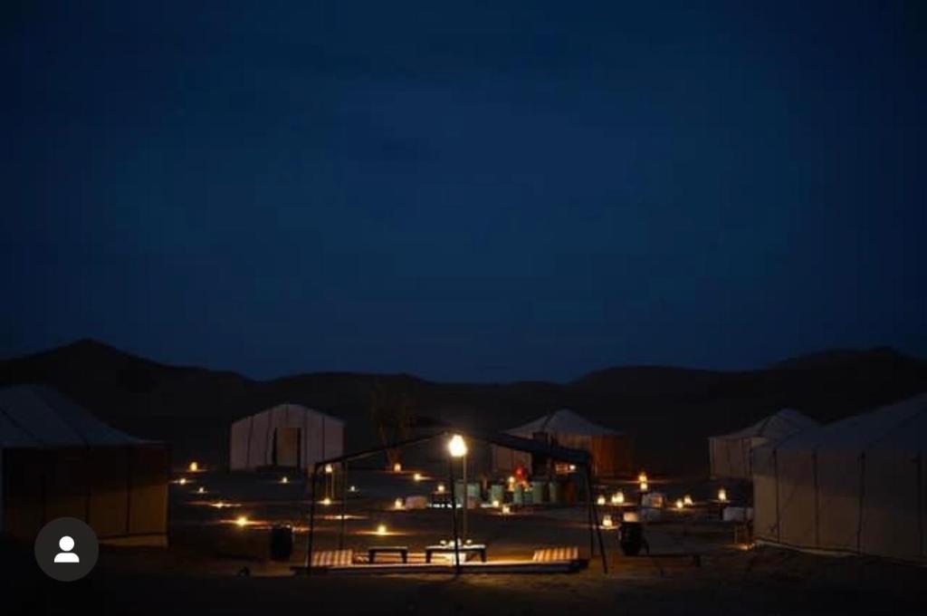 a group of buildings with lights at night at Peace of mind camp in Mhamid