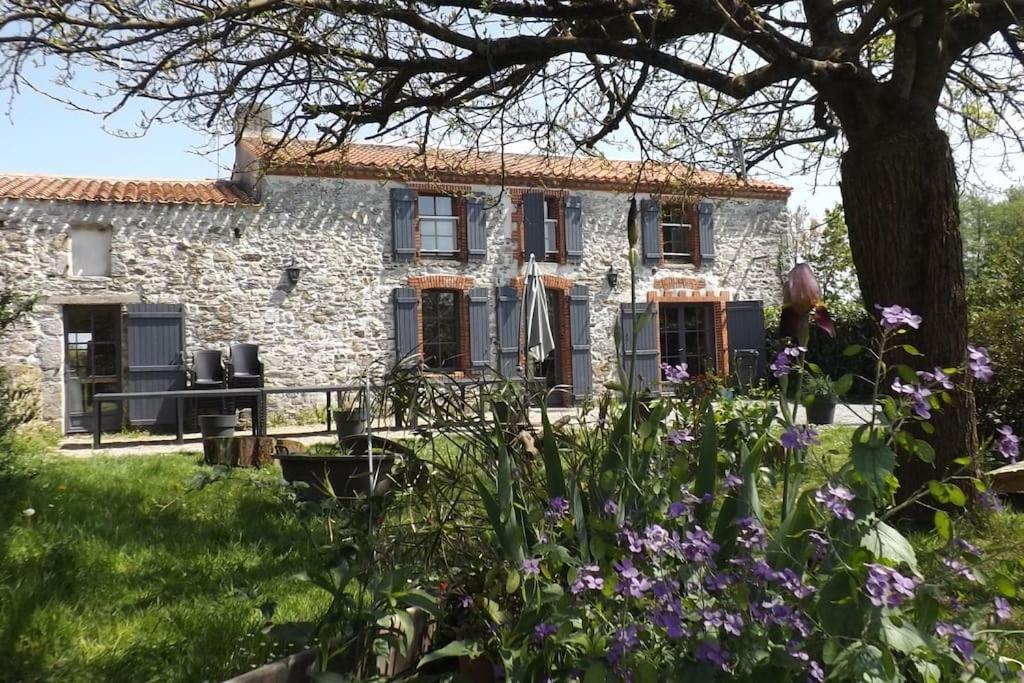 ein Steinhaus mit Blumen davor in der Unterkunft La Faerie - A la campagne - Gite grande capacité in Grand-Landes