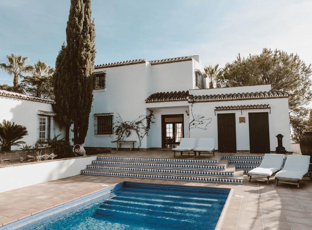 a house with a swimming pool in front of a house at The Collector's House Finca with sea view in Mijas