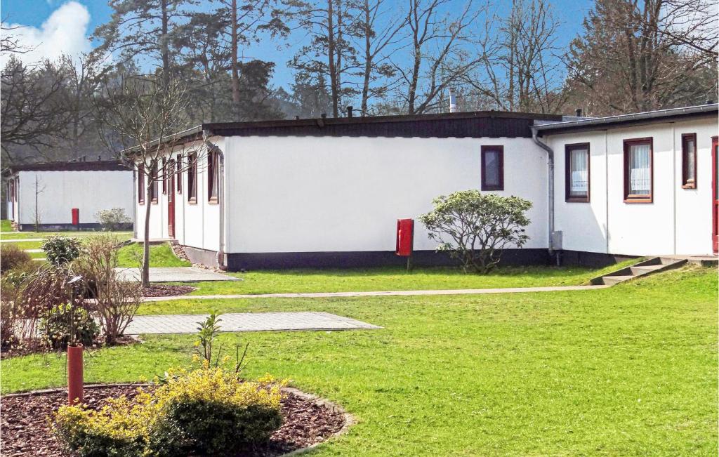 un edificio blanco con una puerta roja en un patio en Beautiful Home In Faberg-heidesee With Kitchen, en Oberohe