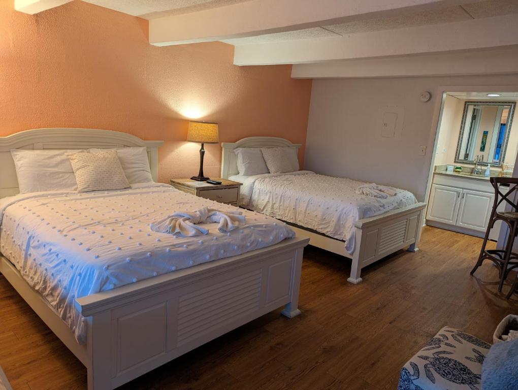 a bedroom with two beds with towels on them at Waterway Condo at Wrightsville! in Wilmington