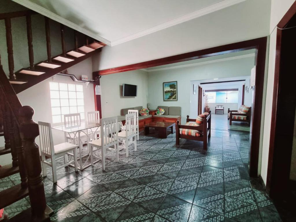 a dining room and living room with a table and chairs at Casa Da Praia in Cabo Frio