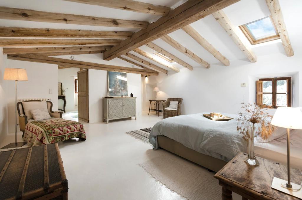 a bedroom with white walls and wooden ceilings at Agroturismo Son Viscos in Valldemossa