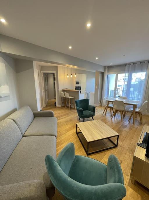 un salon avec un canapé, des chaises et une table dans l'établissement Appartement Roland-Gaross/Boulogne-Billancourt, à Boulogne-Billancourt