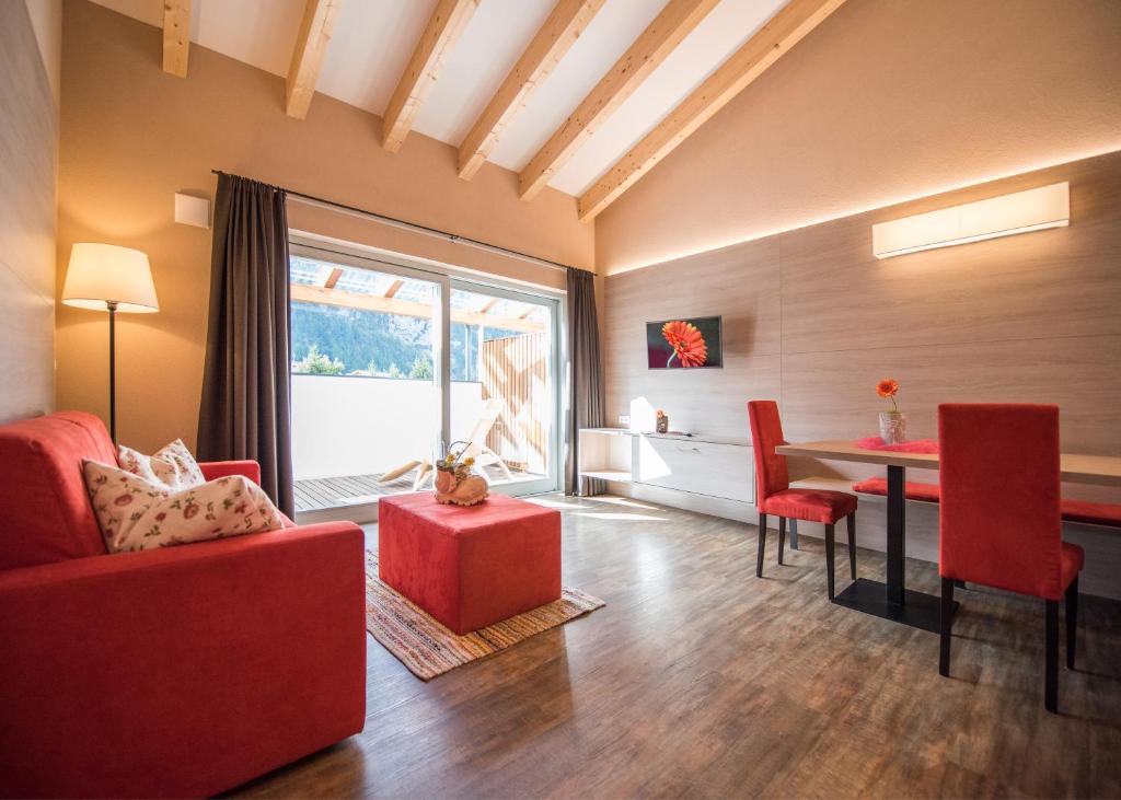 een woonkamer met een rode bank en een tafel bij Alpenblick Nr 9 in Campo Tures