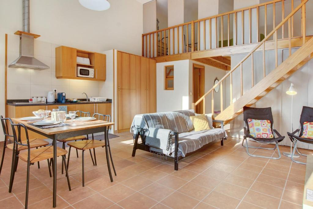 a living room with a table and a dining room at Calheta Lofts ii in Calheta