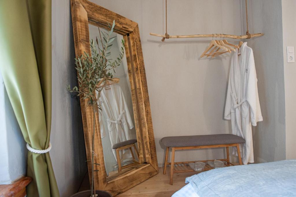 um quarto com um espelho, uma cadeira e uma cama em locanta em Ioannina
